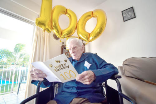 Cayman’s first governor, Athelstan Charles Long, reads a birthday card greeting as he celebrates his birthday at The Pines Retirement Home on Wednesday.